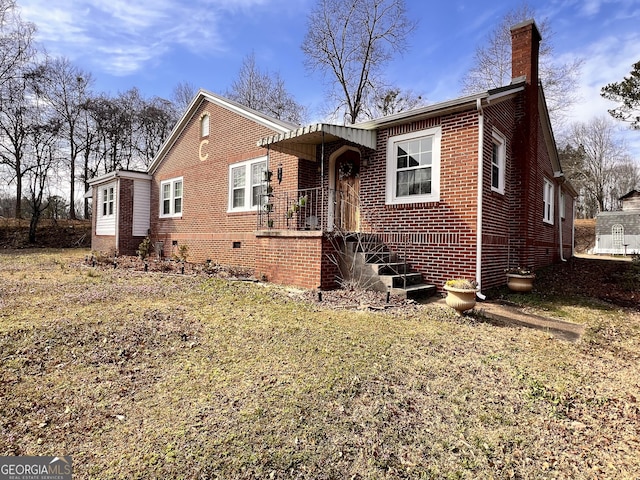 view of front of house featuring brick siding and a chimney