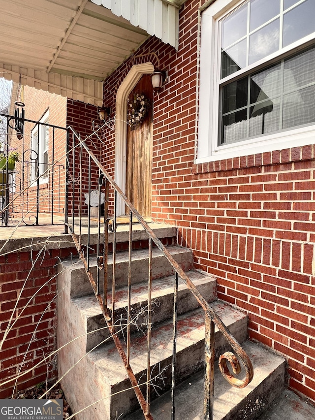 doorway to property featuring brick siding