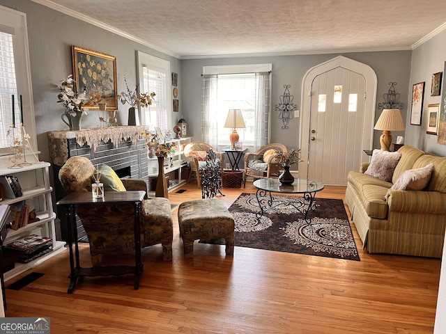 living area featuring a textured ceiling, wood finished floors, and crown molding