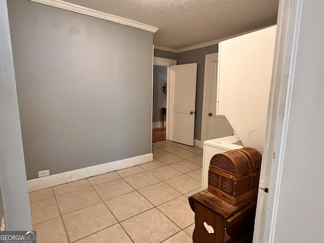 bathroom featuring a textured ceiling, ornamental molding, tile patterned flooring, and baseboards