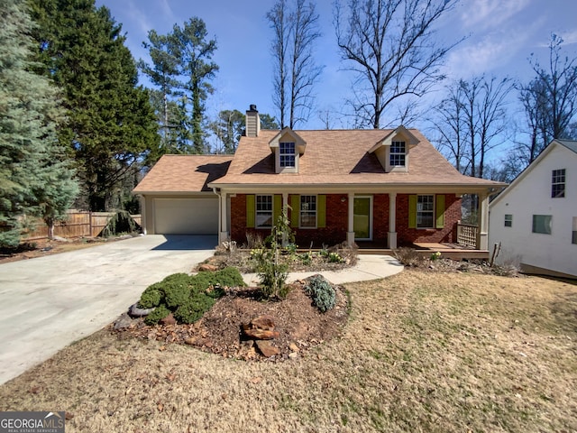 cape cod home with brick siding, concrete driveway, covered porch, an attached garage, and fence