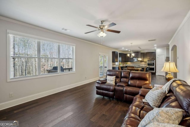 living area with baseboards, dark wood-style floors, visible vents, and crown molding