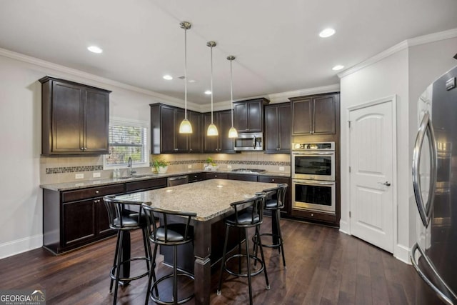 kitchen with dark brown cabinets, appliances with stainless steel finishes, and dark wood finished floors