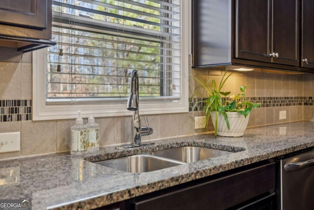 kitchen with stone counters, decorative backsplash, stainless steel dishwasher, a sink, and dark brown cabinets