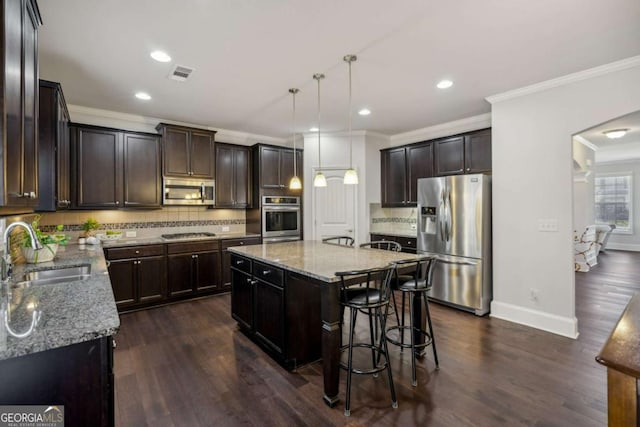 kitchen featuring stainless steel appliances, visible vents, a sink, and light stone countertops