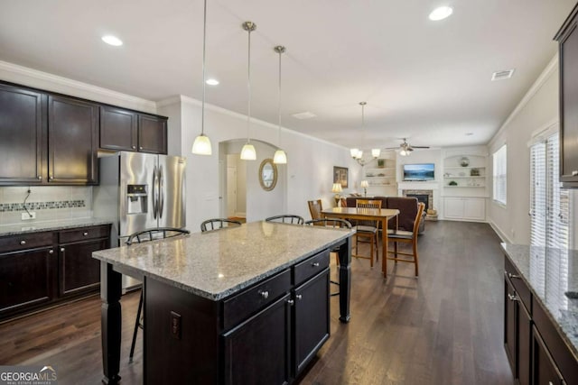 kitchen featuring dark wood-style flooring, a fireplace, open floor plan, and a kitchen bar