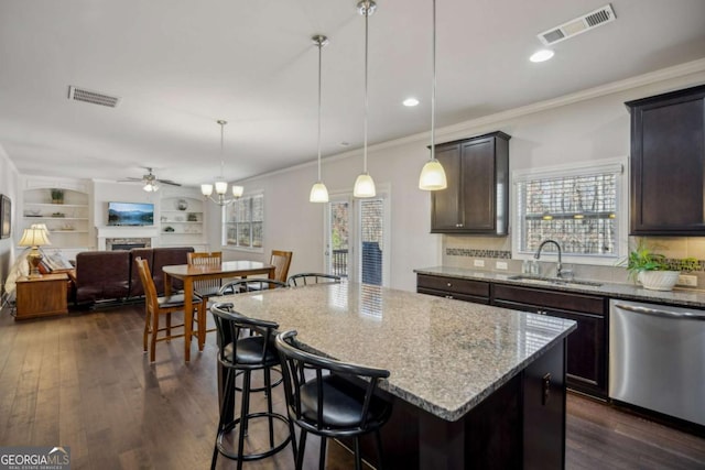 kitchen with visible vents, a sink, stainless steel dishwasher, and light stone countertops