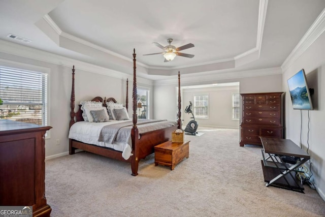 carpeted bedroom featuring crown molding, a raised ceiling, visible vents, ceiling fan, and baseboards