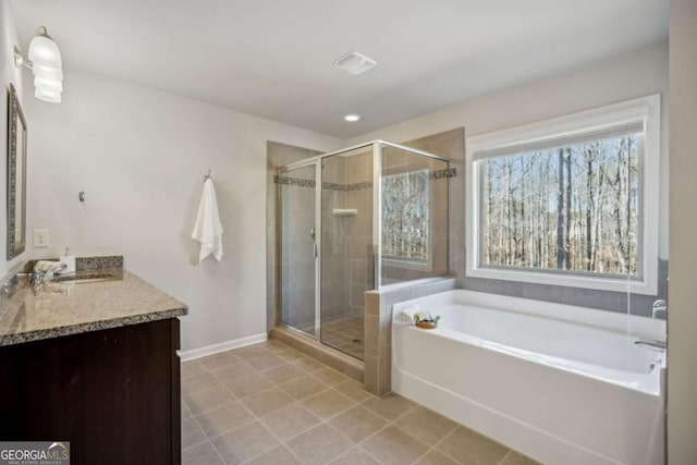 full bathroom featuring a stall shower, a garden tub, vanity, and tile patterned floors