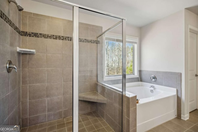 bathroom featuring a stall shower, tile patterned flooring, and a bath