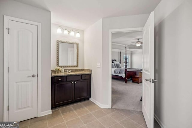 ensuite bathroom featuring baseboards, vanity, ensuite bath, and tile patterned floors