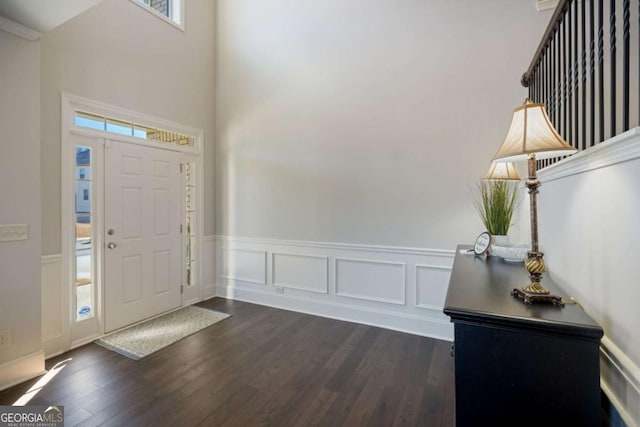 entrance foyer featuring dark wood-type flooring and a wainscoted wall