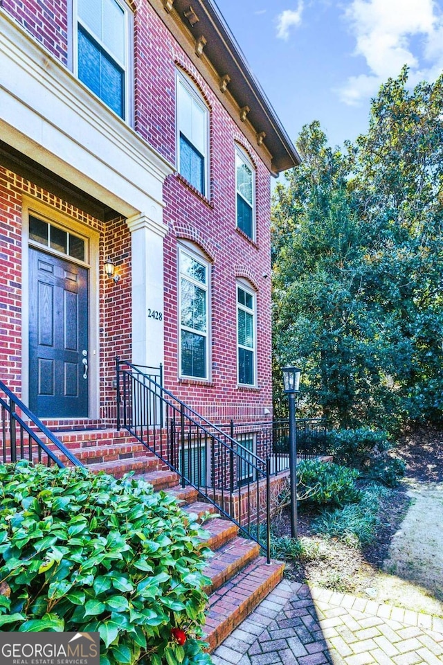 entrance to property featuring brick siding