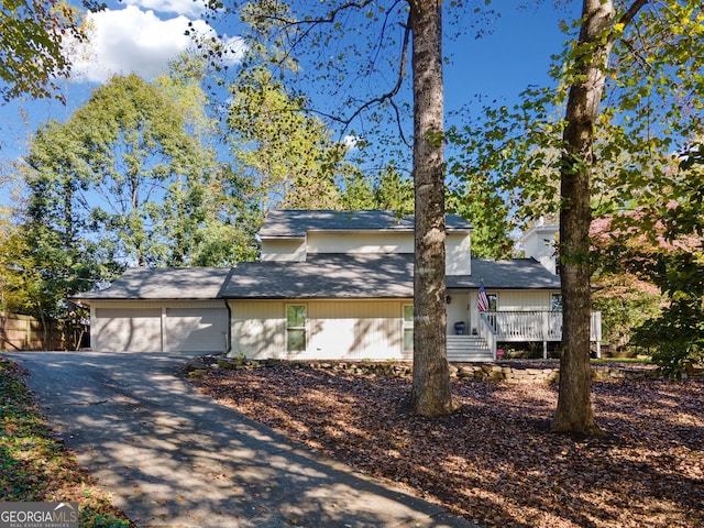 view of front of house with driveway, a chimney, and an attached garage