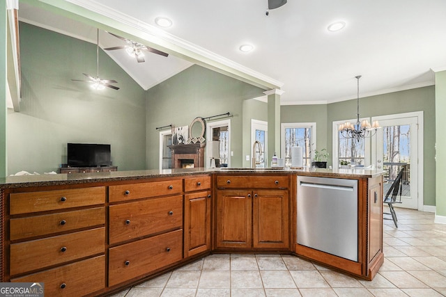 kitchen with light tile patterned floors, brown cabinets, dark stone countertops, open floor plan, and stainless steel dishwasher