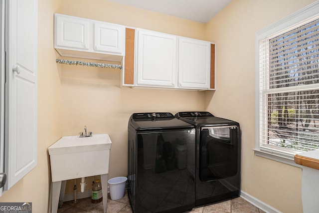 laundry room featuring washer and dryer, cabinet space, and baseboards