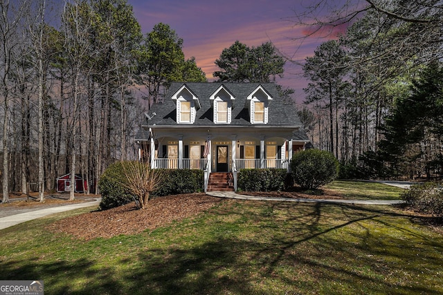 new england style home with a porch and a lawn