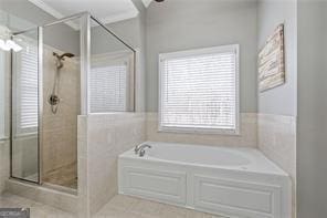 full bath featuring ornamental molding, a shower stall, and a bath