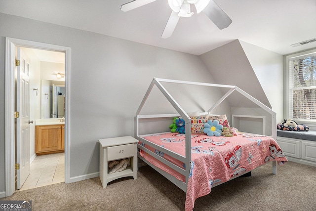 bedroom featuring light carpet, visible vents, connected bathroom, ceiling fan, and light tile patterned flooring