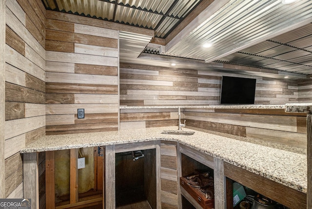 kitchen with wood walls and light stone counters