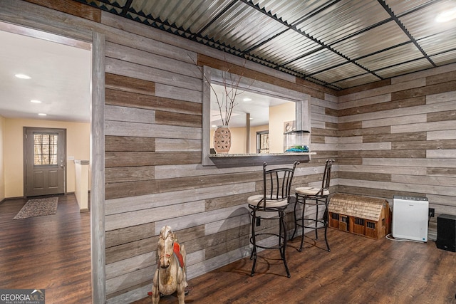 bar with wood walls, wood finished floors, and recessed lighting