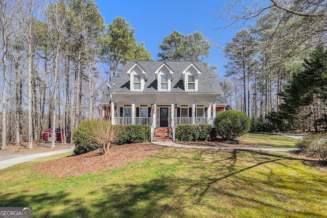 new england style home featuring a front yard and covered porch