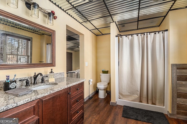 full bath with baseboards, a shower with shower curtain, toilet, wood finished floors, and vanity