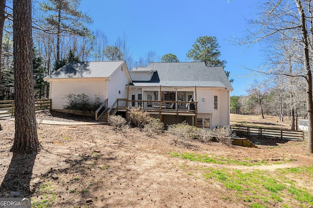 rear view of house with stairway, fence, and a wooden deck