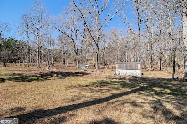 view of yard with a sunroom and a wooded view