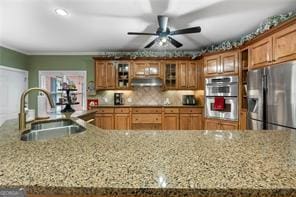 kitchen featuring brown cabinets, backsplash, stainless steel appliances, and a sink