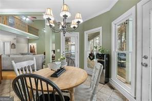 dining room with a healthy amount of sunlight, light tile patterned floors, crown molding, and a notable chandelier