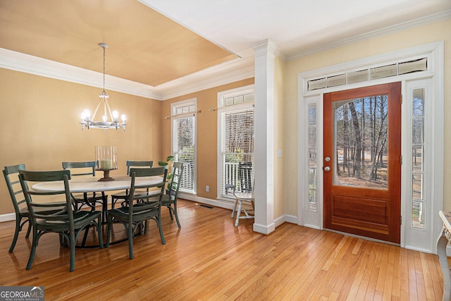 entrance foyer featuring a notable chandelier, crown molding, and light wood-style flooring