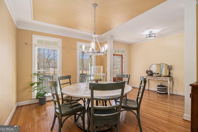 dining area with light wood-style flooring, baseboards, a notable chandelier, and ornamental molding