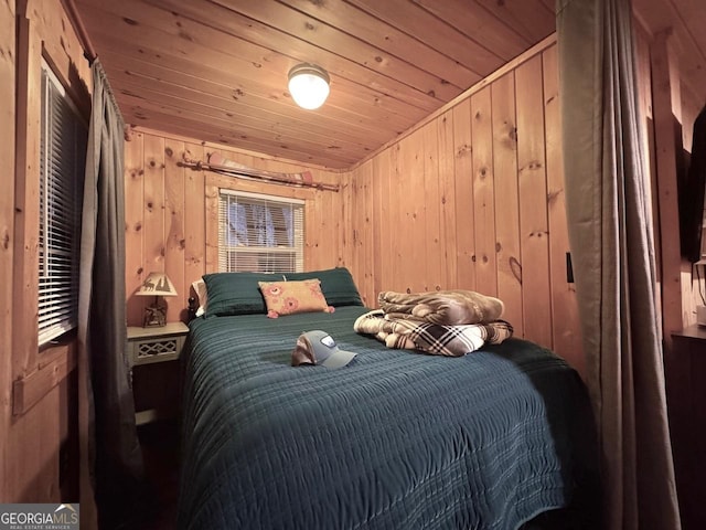 bedroom with wooden ceiling and wood walls