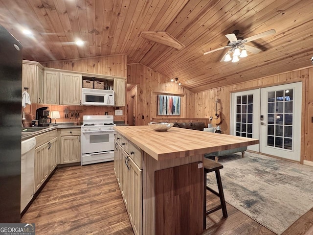 kitchen featuring white appliances, lofted ceiling, butcher block countertops, a breakfast bar area, and french doors