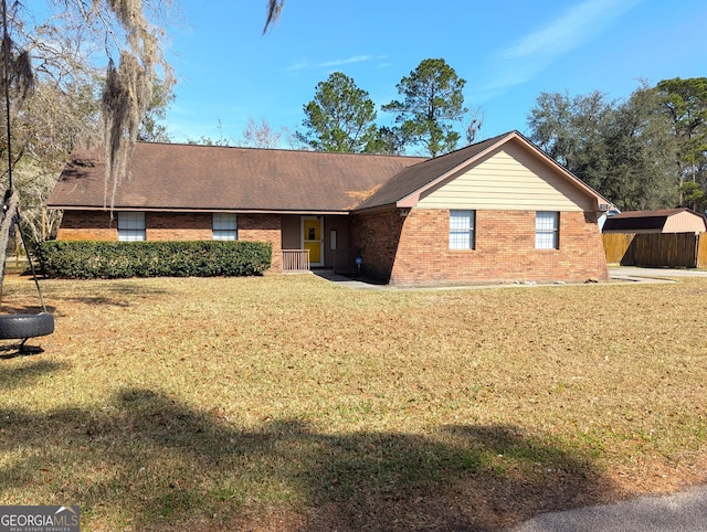 ranch-style home featuring a front yard and brick siding