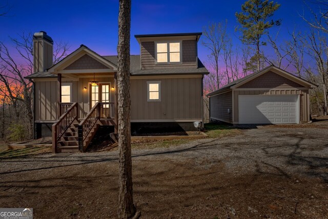 view of front of home with a porch, a detached garage, an outbuilding, and board and batten siding