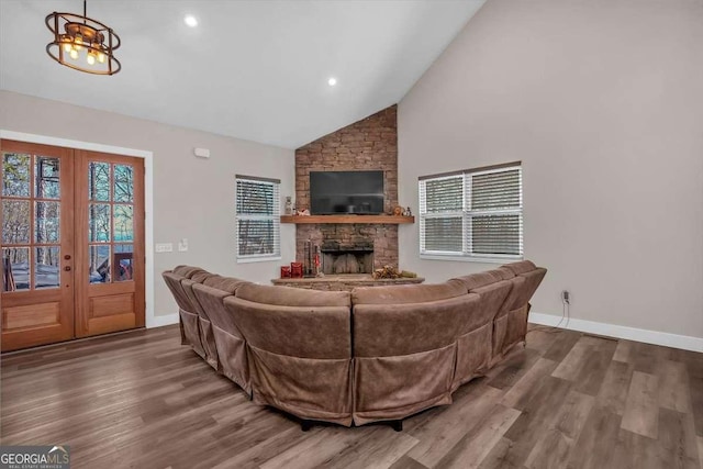 living area with high vaulted ceiling, a fireplace, baseboards, and wood finished floors