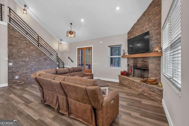 living area featuring baseboards, stairway, wood finished floors, a fireplace, and recessed lighting