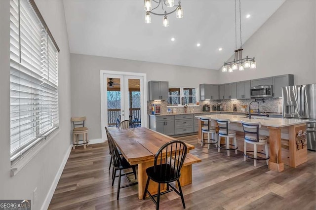 dining room with dark wood-style floors, french doors, plenty of natural light, and baseboards