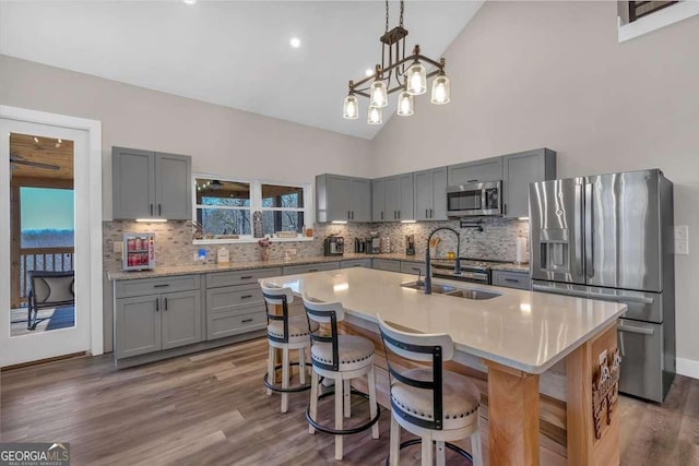 kitchen featuring a sink, appliances with stainless steel finishes, wood finished floors, and gray cabinets