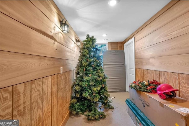 interior space with concrete flooring and wood walls