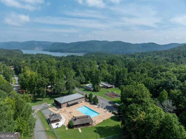 aerial view featuring a forest view and a water and mountain view