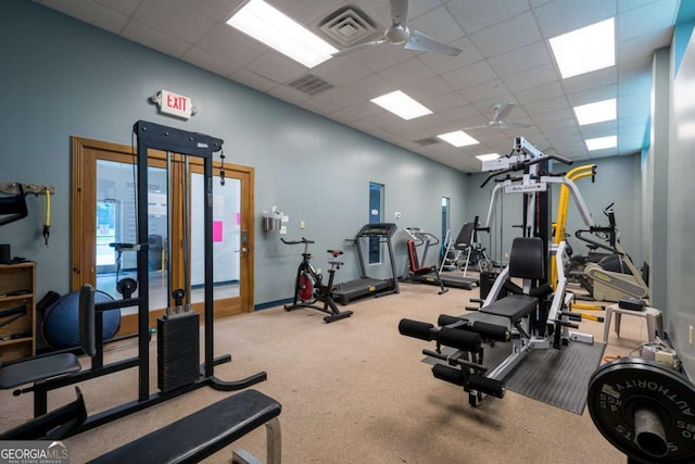 exercise room with a ceiling fan, visible vents, and a drop ceiling