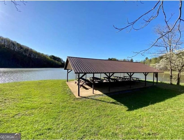 view of home's community with a water view and a lawn