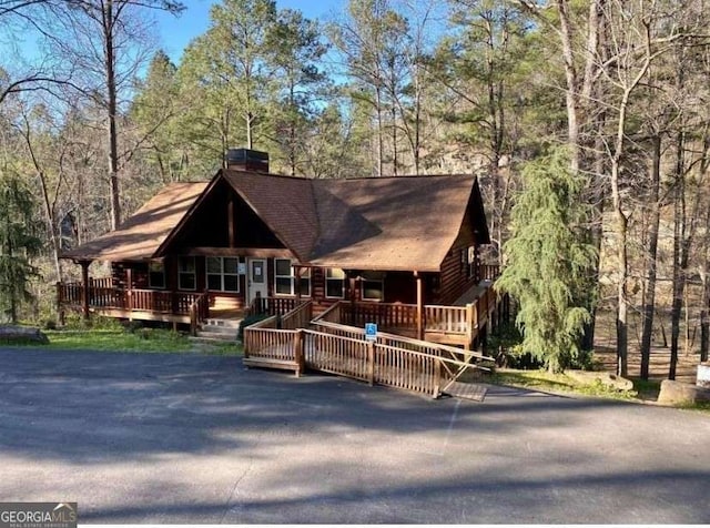 1172 Hunter Dr, Ranger, GA 30734 - view of front facade with a chimney, a view of trees, covered porch, and a deck