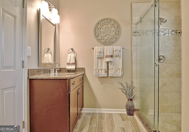 bathroom with a stall shower, vanity, and wood tiled floor