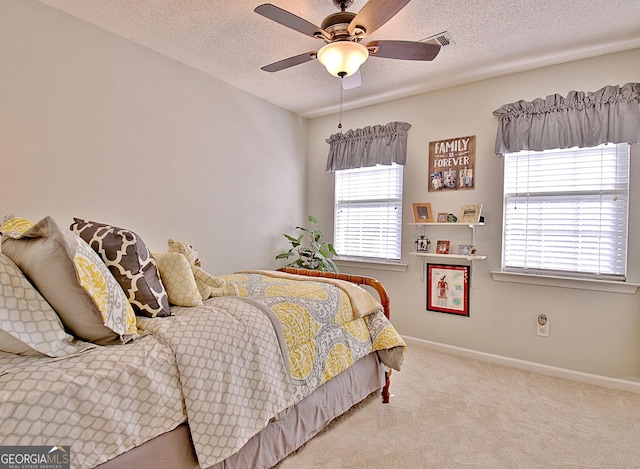 bedroom with carpet, visible vents, a ceiling fan, a textured ceiling, and baseboards