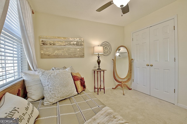 carpeted bedroom featuring ceiling fan, a closet, and baseboards