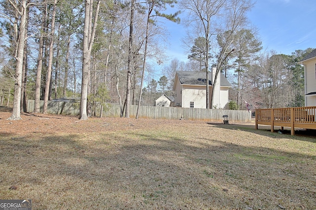 view of yard featuring fence and a deck